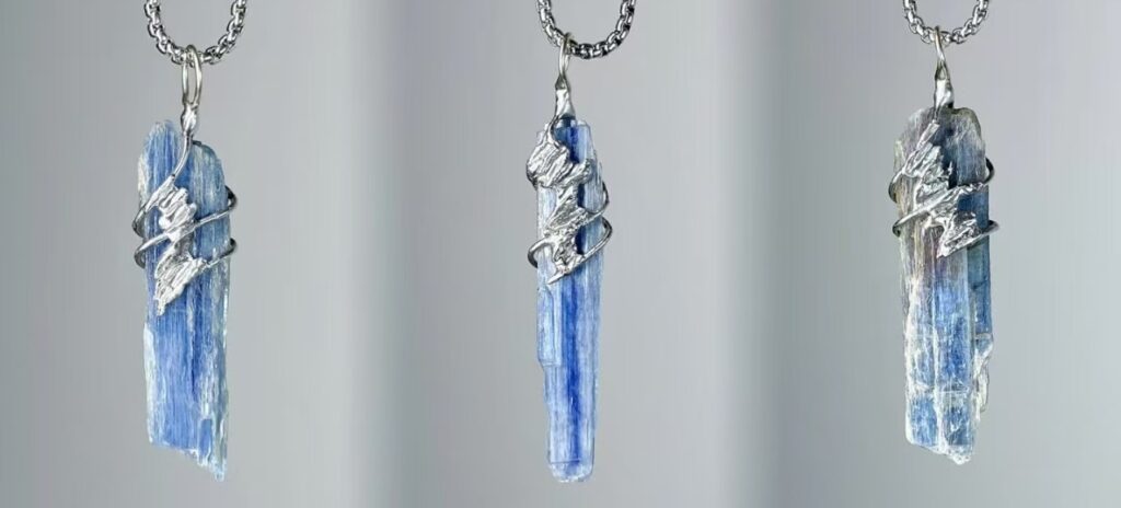 Natural blue kyanite pendant necklace with hand-soldered tin wire design, resembling ocean waves and glaciers.
